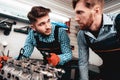 Two Auto Mechanics Are Checking Detail In Garage. Royalty Free Stock Photo