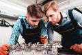 Two Auto Mechanics Are Checking Detail In Garage. Royalty Free Stock Photo