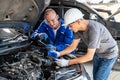 Two auto mechanics using a computer measuring device to check the car Royalty Free Stock Photo