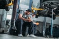 two auto mechanics using smartphone and resting in auto Royalty Free Stock Photo