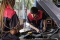 Two automotive mechanical partners check an EV car at a fixing garage.