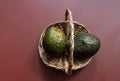 Two avocados on an antique wicker basket