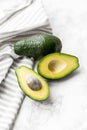 Two avocados on a marble backgroundand a kitchen towel . Avocado cut Royalty Free Stock Photo