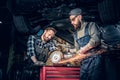 Two b mechanics working with an angle grinder in a garage. Royalty Free Stock Photo