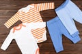 Two babies bodysuits and pants on wooden background. Baby clothe Royalty Free Stock Photo