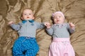 Two babies lying on bad and grimacing Royalty Free Stock Photo