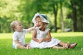 Two babies are sitting on the grass