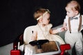 Two babies wedding - boy and girl dressed as bride and groom playing with toy car Royalty Free Stock Photo