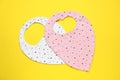 Two baby bibs on yellow background, top view. First food Royalty Free Stock Photo