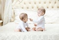 Two baby boys playing on bed