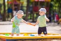 Two baby boys playing with sand Royalty Free Stock Photo