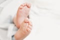 Two baby feet on the background of white bed linen. Ukrainian newborn. baby`s little toes. top view Royalty Free Stock Photo