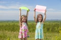 Two baby girls in summer dresses on the nature of holding the co Royalty Free Stock Photo