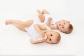Two baby twins boy and girl with a bottle of milk on a white bed at home, baby food concept Royalty Free Stock Photo