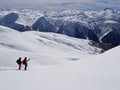 Two backcountry skiers hiking to a far away mountain peak in the Austrian Alps in winter Royalty Free Stock Photo