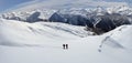 Two backcountry skiers hiking to a far away mountain peak in the Austrian Alps in winter Royalty Free Stock Photo