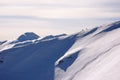 Two backcountry skiers hiking up on a long mountain ridge towards the summit near Klosters in the Swiss Alps in deep winter Royalty Free Stock Photo