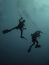 Two backlit divers in the Red Sea, off the coast of Yambu in Saudi Arabia starting a dive