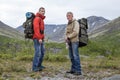 Two backpackers hiking in mountains. Senior and young adult men looking at camera Royalty Free Stock Photo