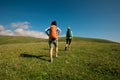 Backpacking women friends hiking in grassland mountains Royalty Free Stock Photo