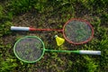 Two badminton rackets with a yellow shuttlecock on the green grass, summer active games Royalty Free Stock Photo