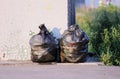 two bags of garbage near the bus stop