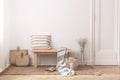 Two bags made of straw next to wooden table with striped pillow