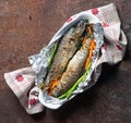 Two baked fish in foil in a basket Royalty Free Stock Photo