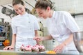 Two baker women in pastry bakery working on muffins