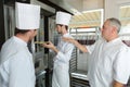 Two bakers in bakery or bakehouse baking pretzels