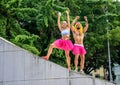 Two ballerinas, male and female, in bright pink tutu skirts standing at the Memorial Getulio Vargas