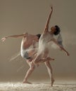 Two ballet dancers perform dance against background of white flour cloud in air Royalty Free Stock Photo