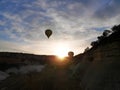 Two balloons taking off at sunrise