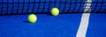 Two balls by the net of a paddle tennis court Royalty Free Stock Photo