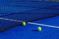 Two balls next to the net of a paddle tennis court. Racket sport concept Royalty Free Stock Photo