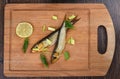 Two baltic herrings cold smoked with dill, green onions and lime on a wooden cutting board Royalty Free Stock Photo