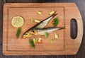 Two baltic herrings cold smoked with dill, green onions and lime on a wooden cutting board Royalty Free Stock Photo