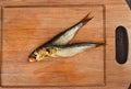 Two baltic herrings cold smoked on a wooden cutting board Royalty Free Stock Photo