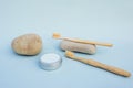 Two bamboo toothbrushes and round silver can on light blue background. with grey natural stones. Organic toothpowder and zero Royalty Free Stock Photo