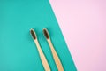 Two bamboo toothbrushes on turquoise pink background. Love, healthcare, zero waste, treatment concept.