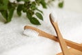 Two bamboo toothbrushes on white towel