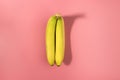 Two bananas isolated on a pink background