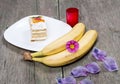 Two bananas, plate with cake decorated with flowers