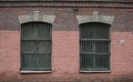 Two barred windows in an old red brick wall Royalty Free Stock Photo