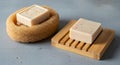 Two bars of soap are featured. One soap sits atop a natural loofah sponge, exhibiting a rectangular Royalty Free Stock Photo