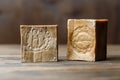 Two bars of traditional aged aleppo organic laurel soap on a brown wooden background