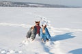 Two basenji in funny dog costumes playing in the snow