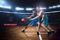 Two basketball players during scrimmage on indoor basketball court