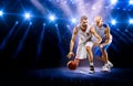 Two basketball players in spotlights