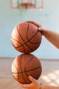 Two basketballs in male hands